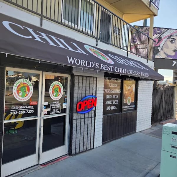 Exterior of Chili Shack, a Mexican restaurant, with a black awning and an "OPEN" sign.