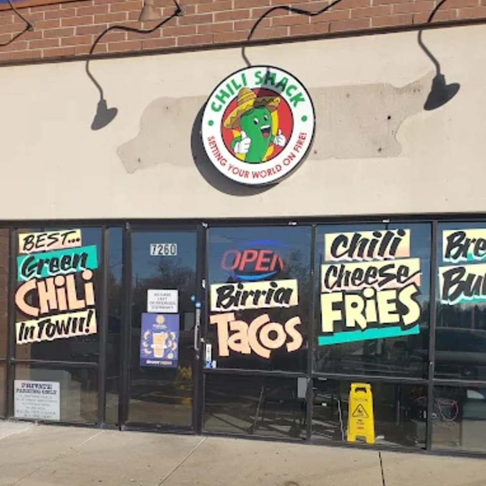 The Chili Shack storefront with a chili pepper logo and signs for green chili, birria tacos, and chili cheese fries.